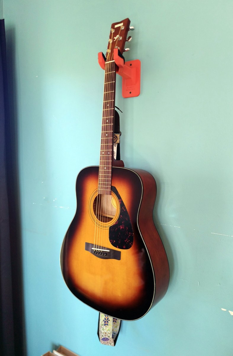 The guitar hanging from the hook, seen from the side
